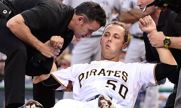 Athletic trainers Ben Potenziano left and Todd Tomczyk right help Pittsburgh Pirates starting pitcher Jameson Taillon to sit up in the second inning of a baseball game against the Milwaukee Brewers in Pittsburgh Tuesday