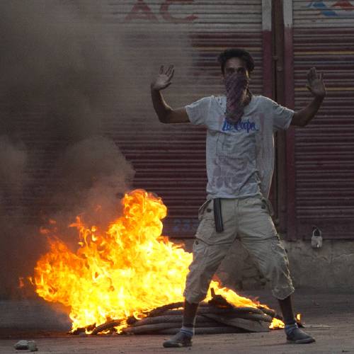 Kashmiri protester shouts freedom slogan near burning tires set up as road blockade by protesters in Srinagar Indian controlled Kashmir Tuesday