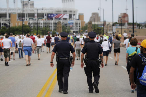 Police officers walk among people marching to join hands in a peace rally amid preparations for the arrival of visitors and delegates for the Republican National Convention