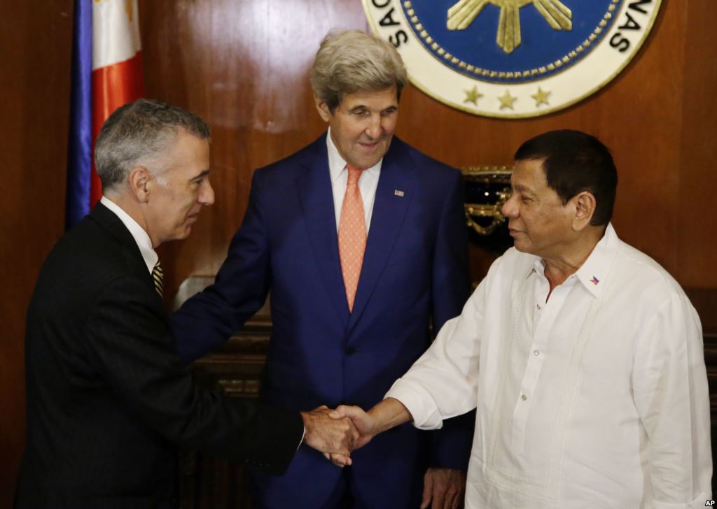 Philippine President Rodrigo Duterte right greets U.S. Ambassador to the Philippines Philip S. Goldberg left as Secretary of State John Kerry looks on during his visit at the Malacanang presidential palace in Manila Philippines on Wednesday July 27