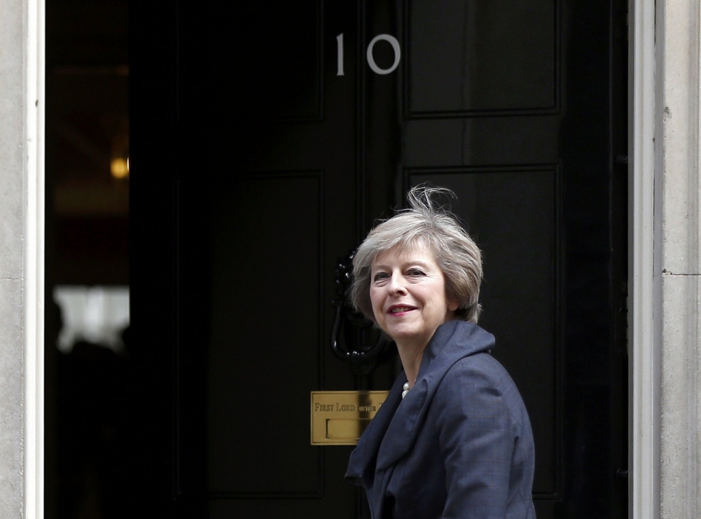 Welcome home Prime Minister: Theresa May arrives for David Cameron's last cabinet