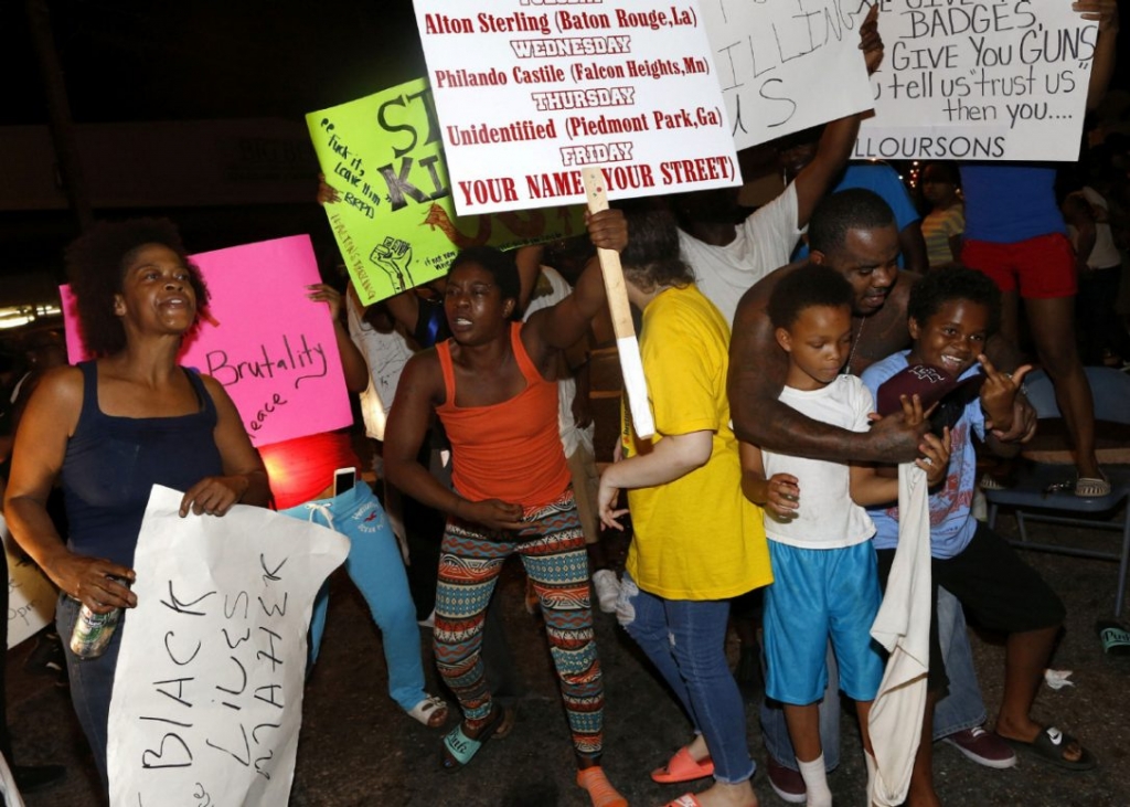 Protesters during a third night of protesting in Baton Rouge march Thursday outside the Triple S Food Mart where Alton Sterling was killed by police