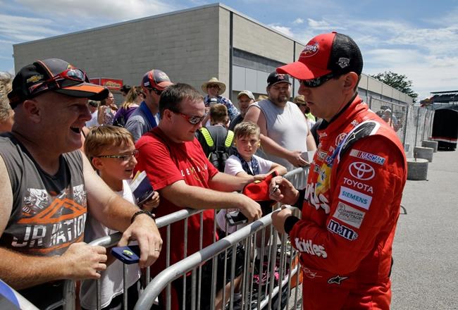 Sprint Cup Series driver Kyle Busch signs autographs for fans following a practice session for the Brickyard 400 NASCAR auto race at the Indianapolis Motor Speedway in Indianapolis Friday