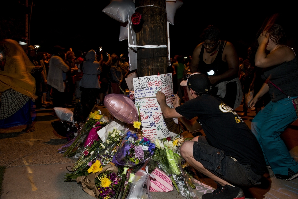 Protestors sign a memorial at the intersection where Philando Castile was shot on Thursday in Falcon Heights Minnesota. Castile was shot and killed by a police officer during a traffic stop on Wednesday