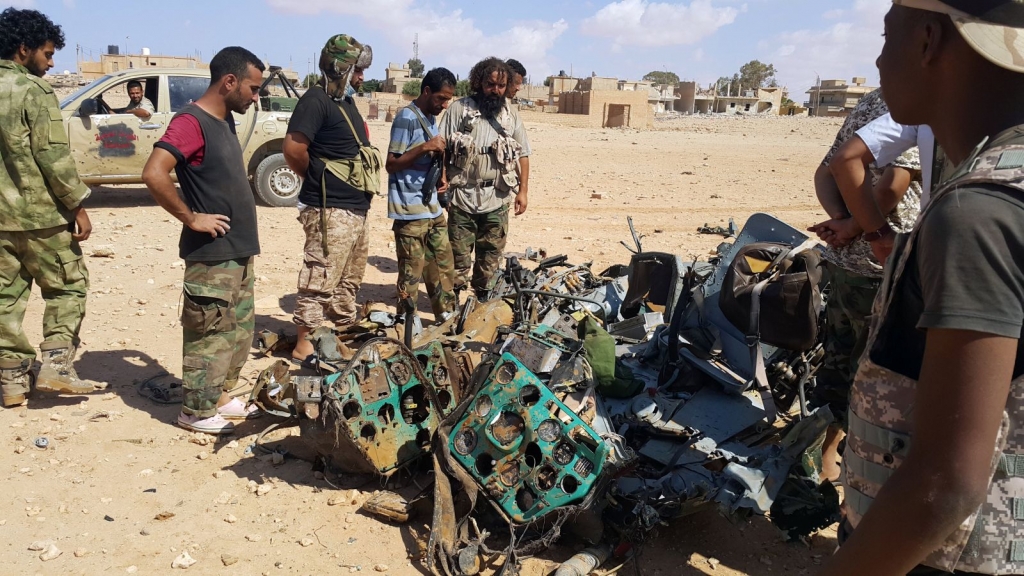 Libyans gather around the remains of a helicopter that crashed near Benghazi Libya