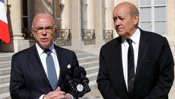 Interior Minister Bernard Cazeneuve and Defence Minister Jean Yves Le Drian speak to journalists before leaving the Elysee Palace in Paris France