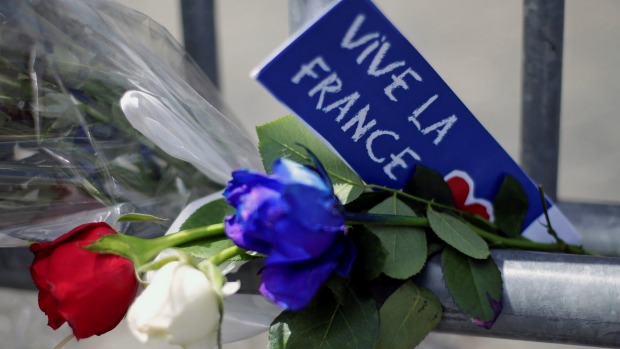 Flowers are seen attached to a fence to remember the victims of the Bastille Day truck attack in Nice