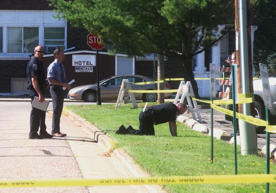 Law enforcement officers check for any evidence possibly left behind at the scene of a traffic stop where shots were fired in Antigo Wis. Tuesday