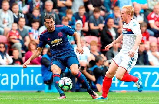 Manchester United's Henrikh Mkhitaryan in action with Wigan Athletic's David Perkins