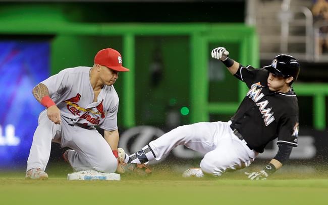 Miami Marlins&#39 Christian Yelich slides safely into second base after hitting a double against the St. Louis Cardinals as second baseman Kolten Wong is unable to tag out Yelich during the first inning of a baseball game Saturday