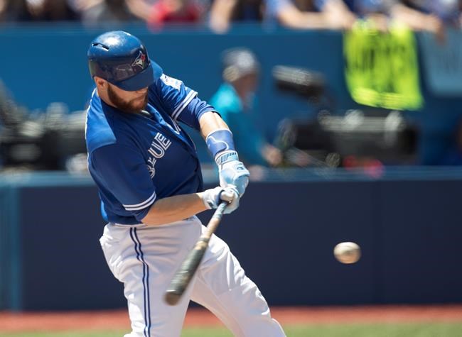 Toronto Blue Jays&#39 Russell Martin hits a three-run home run against the Cleveland Indians during first inning American League MLB baseball action in Toronto on Sunday