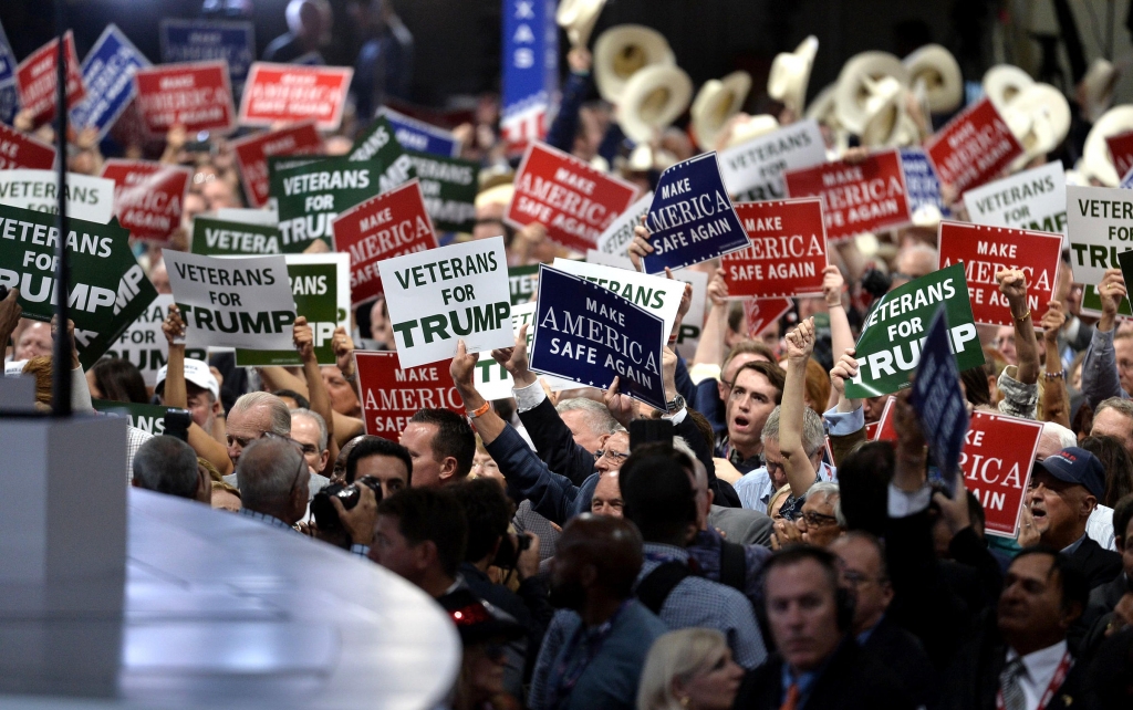 Delegates hold signs on the first day of the Republican National Convention on Monday evening at the Quicken Loans Arena in Cleveland Ohio