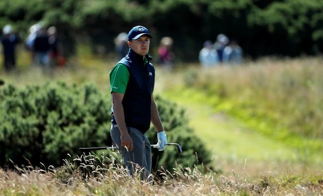 Jordan Spieth of the United States looks to see where his ball has landed after playing out of the rough on the edge of the 11th green during the first round of the British Open Golf Championship at the Royal Troon Golf Club in Troon Scotland Thursday