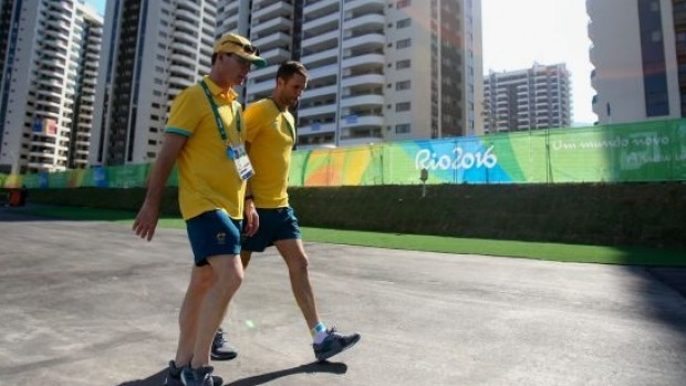 Members of the Australian hockey team walk at the Olympic Village before the fire