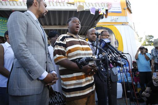 Cameron Sterling center son of Alton Sterling who was killed by Baton Rouge police last Tuesday speaks to the media outside the Triple S Food Mart where his father was killed in Baton Rouge La. Wednesday