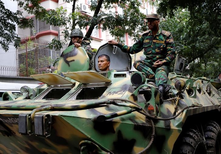 Army soldiers atop an armored military vehicle drive near the Holey Artisan restaurant after Islamist militants attacked the upscale cafe in Dhaka