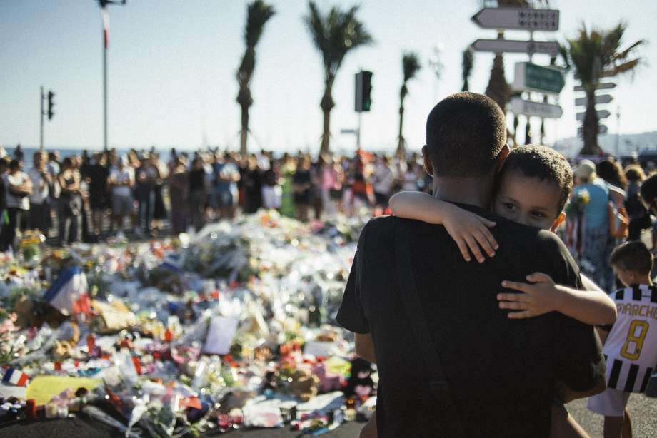 Mourners gather at a makeshift memorial at the Promenade des Anglais in Nice France where a man drove a 19-ton truck through a crowd celebrating Bastille Day killing 84 people