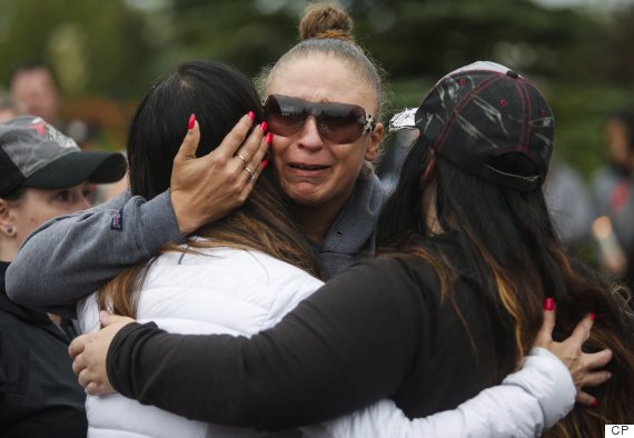 Mourners embrace at a vigil for Sara Baillie and her daughter Taliyah Marsman