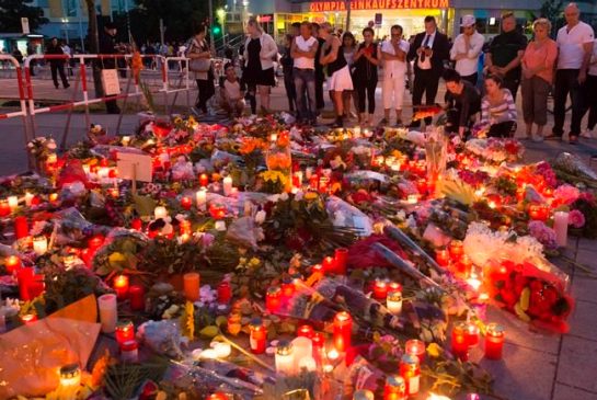 People gather to mourn with flower tributes near to the Olympia shopping center where a shooting took place leaving nine people dead the day before in Munich Germany Saturday