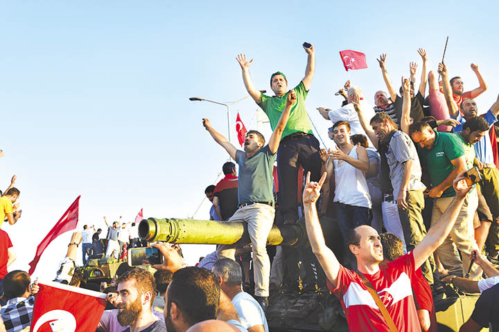 FOILED COUP D’ETAT – Local Turks climb up a tank after taking over a military position on the Bosphorus Bridge in Istanbul on Saturday. At least 161 people mostly civilians were killed and 2,839 were detained in a night of violence across Turkey whe