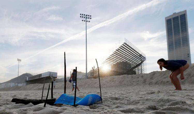 A woman looks at a part of a mutilated body that washed up near the construction site of the beach volleyball venue for the 2016 Rio Olympics