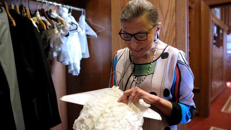 U.S. Supreme Court Justice Ruth Bader Ginsburg shows the many different collars she wears with her robes in her chambers at the Supreme Court building in Washington