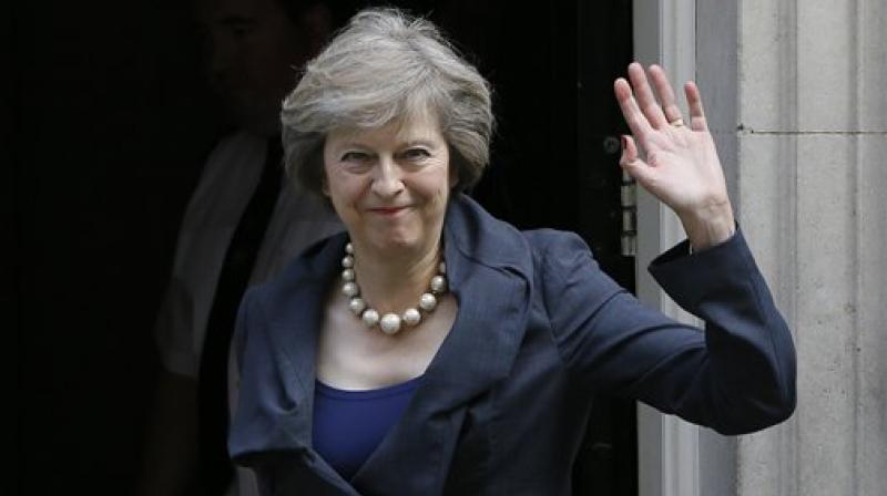 Britain's Home Secretary Theresa May waves towards the media as she arrives to attend a cabinet meeting at 10 Downing Street in London