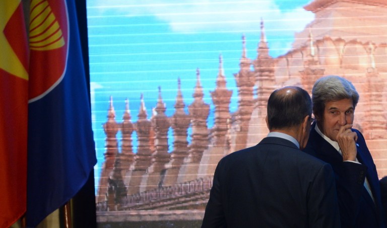 US State Secretary John Kerry right talks to Russia's Foreign Minister Sergey Lavrov as they prepare to pose for a group