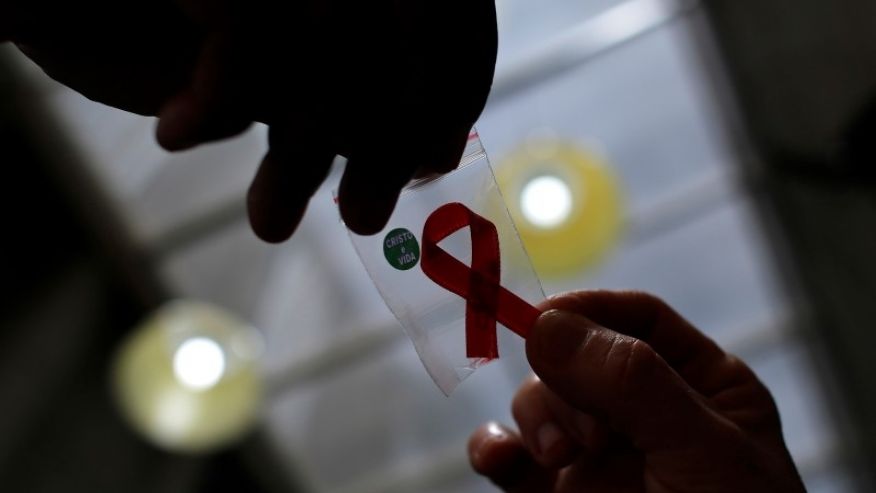 Nurse gives a red ribbon to a woman to mark World Aids Day at the entrance of Emilio Ribas Hospital in Sao Paulo