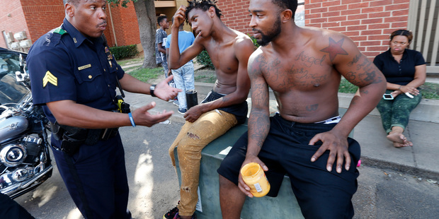 Dallas Police Sergeant A.P. Martin talks with Ja'Shon Kelley 19 left and Anthony Williams 23 while performing community patrol in southwest Dallas