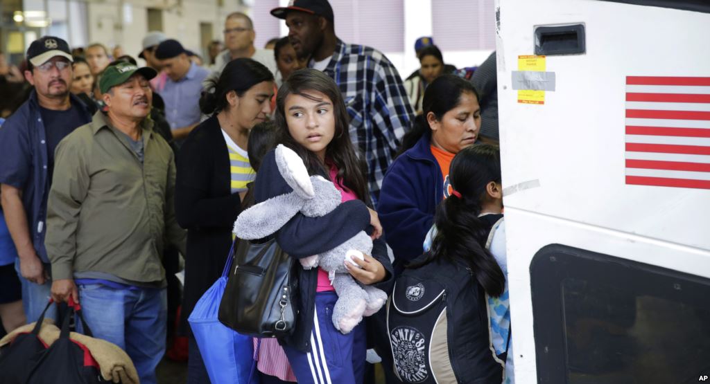 FILE- Immigrants from El Salvador and Guatemala who entered the country illegally board a bus after they were released from a family detention center in San Antonio Texas