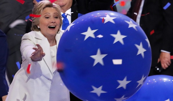 Democratic presidential nominee Hillary Clinton reaches for a falling balloon at the conclusion of the Democratic