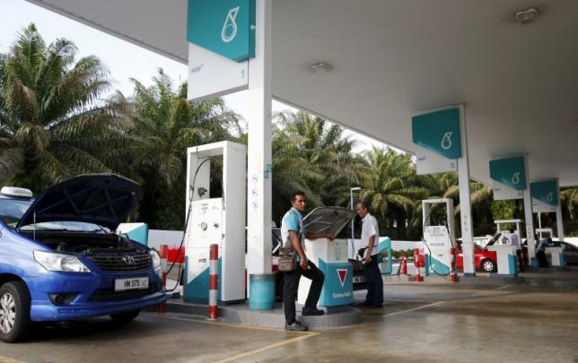 A pump attendant works at a Petronas petrol station outside Kuala Lumpur Malaysia