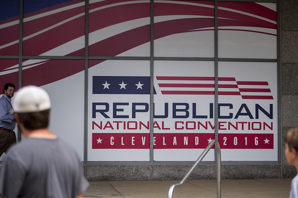 Pedestrians walk past a Republican National Convention sign at the Quicken Loans Arena'The Q in Cleveland Ohio U.S. on Thursday