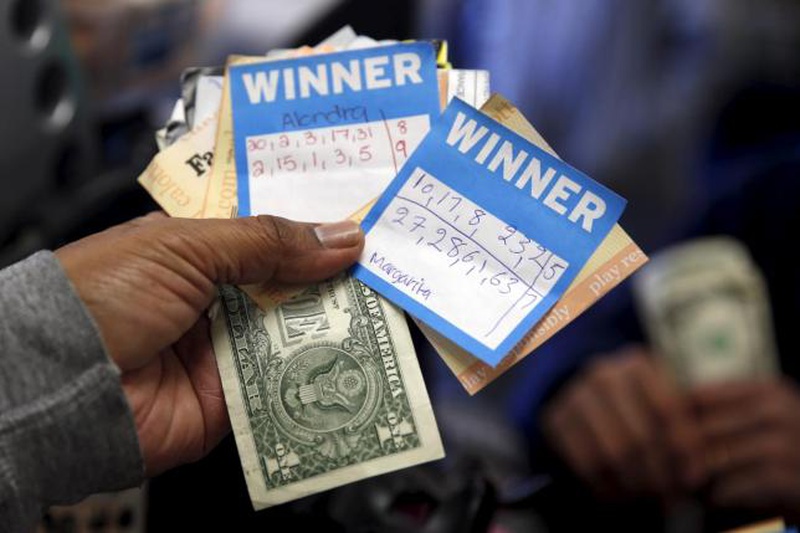 A man holds Powerball lottery ticket numbers chosen by his wife and daughters at Bluebird Liquor in Hawthorne Los Angeles California United States