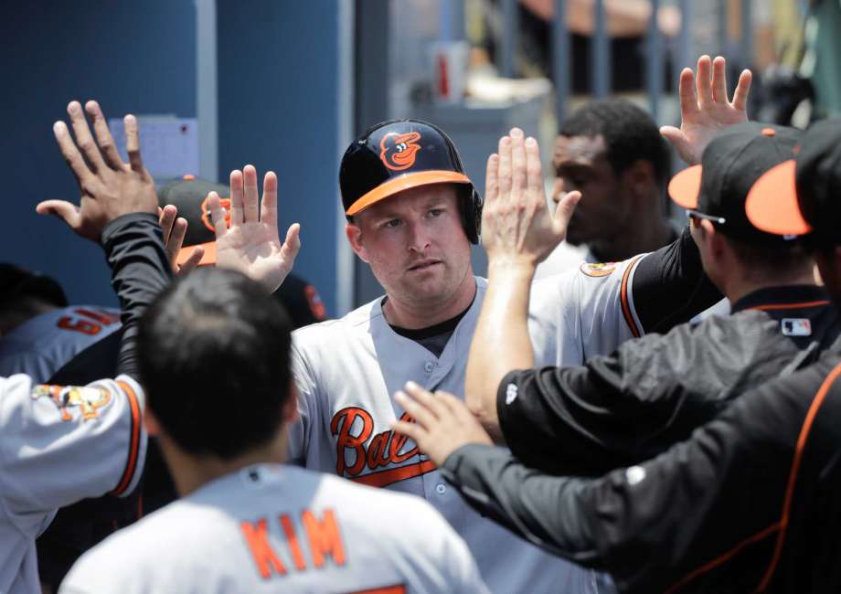 Baltimore Orioles Mark Trumbo center is greeted by teammates after he scored on a double hit by Ryan Flaherty during the second inning of a baseball game against the Los Angeles Dodgers Wednesday