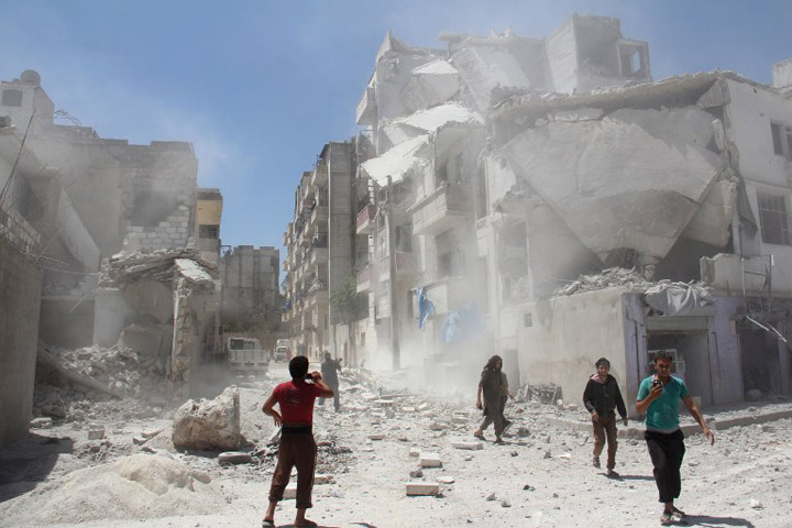 Syrian civilians react following a reported air strike by Syrian government forces on the rebel-held northwestern city of Idlib