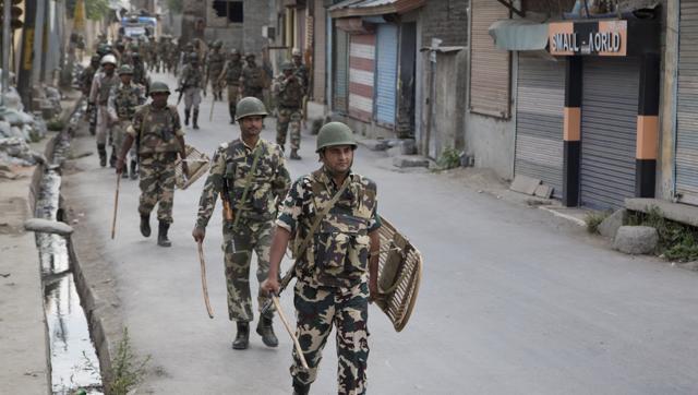 Paramilitary soldiers walk back towards their base camp during curfew in Srinagar