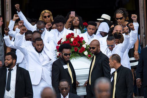 Pallbearers raise their fists into the air as they carry the casket of Philando Castile back to the horse drawn carriage following Castile's funeral service at The Cathedral of Saint Paul Thursday