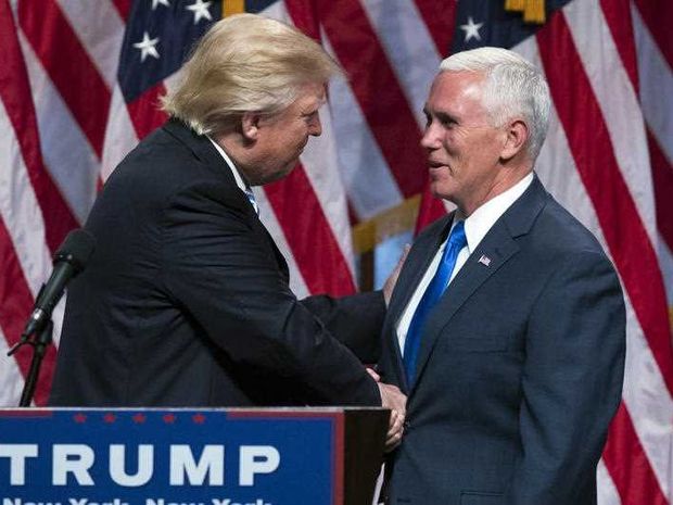 Republican presidential candidate Donald Trump left shakes hands with Gov. Mike Pence R-Ind. during a campaign event to announce Pence as the vice presidential running mate on Saturday