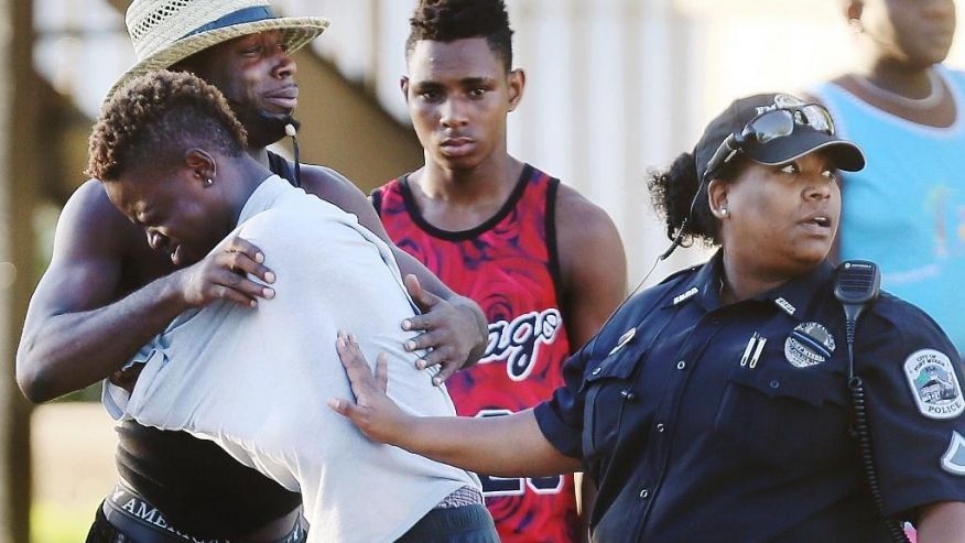 People embrace after a fatal shooting at Club Blu in Fort Myers Fla. Monday