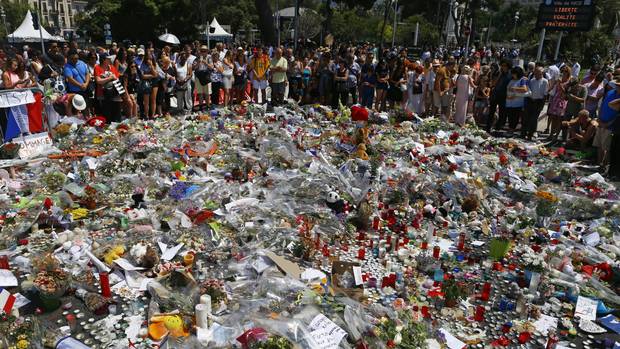 People gather at the makeshift memorial to victims of the Nice truck attack