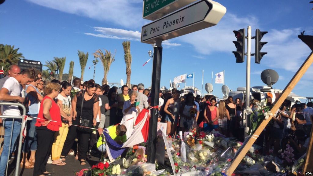 People lay flowers and mementos in honor of the Bastille Day truck attack victims