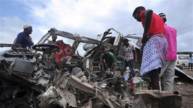 People look at the wreckage of a minibus ripped by a bomb