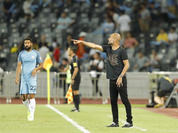 Manchester City manager Pep Guardiola center leaves the field after his team's training session at the Olympic Sports Center Stadium in Beijing China. City play Borussia Dortmund in a friendly match at Shenzhen’s Longgang Stadium on Thursday July 28