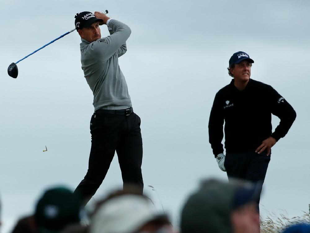 Henrik Stenson of Sweden left plays off the 13th tee watched by playing partner Phil Mickelson of the United States centre during the third round of the British Open Golf Championship at the Royal Troon Golf Club in Troon Scotland Saturday July 16