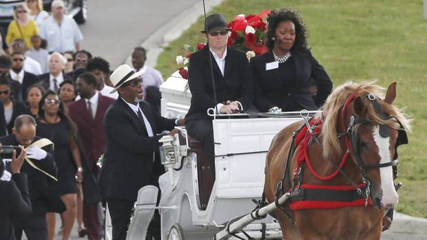 Valerie Castile right rides in the horse-drawn carriage with the casket of of her son Philando Castile during the procession to the Cathedral of Saint Paul in Minnesota