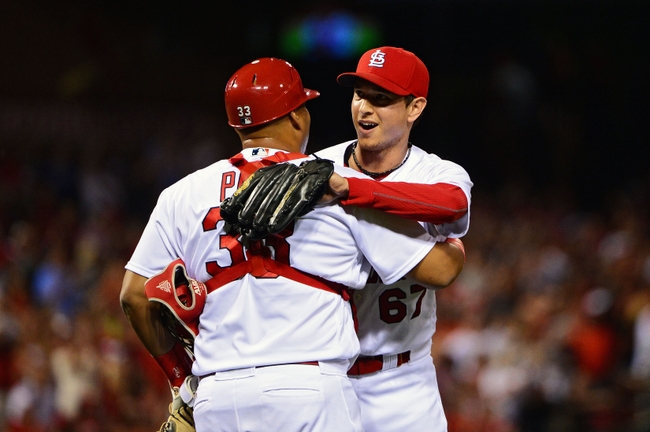 Cardinals hold off Brewers in rain to complete sweep