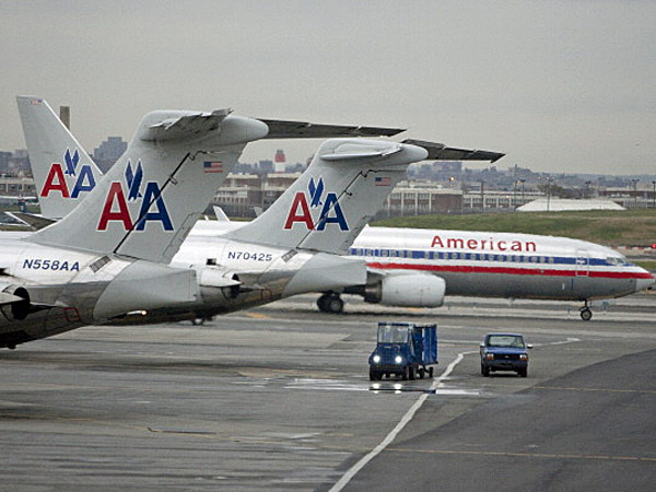 An American Airlines Inc. plane taxis past two others at La Guardia airport in New York U.S. on Tuesday Nov. 22 2011. U.S. travel during the Thanksgiving holiday weekend will rise 4 percent from last year as Americans take trips they had put off becaus