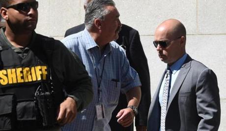 Baltimore Police Lt. Brian Rice right is escorted to a waiting car after being found not guilty on all charges related to the death of Freddy Gray Monday